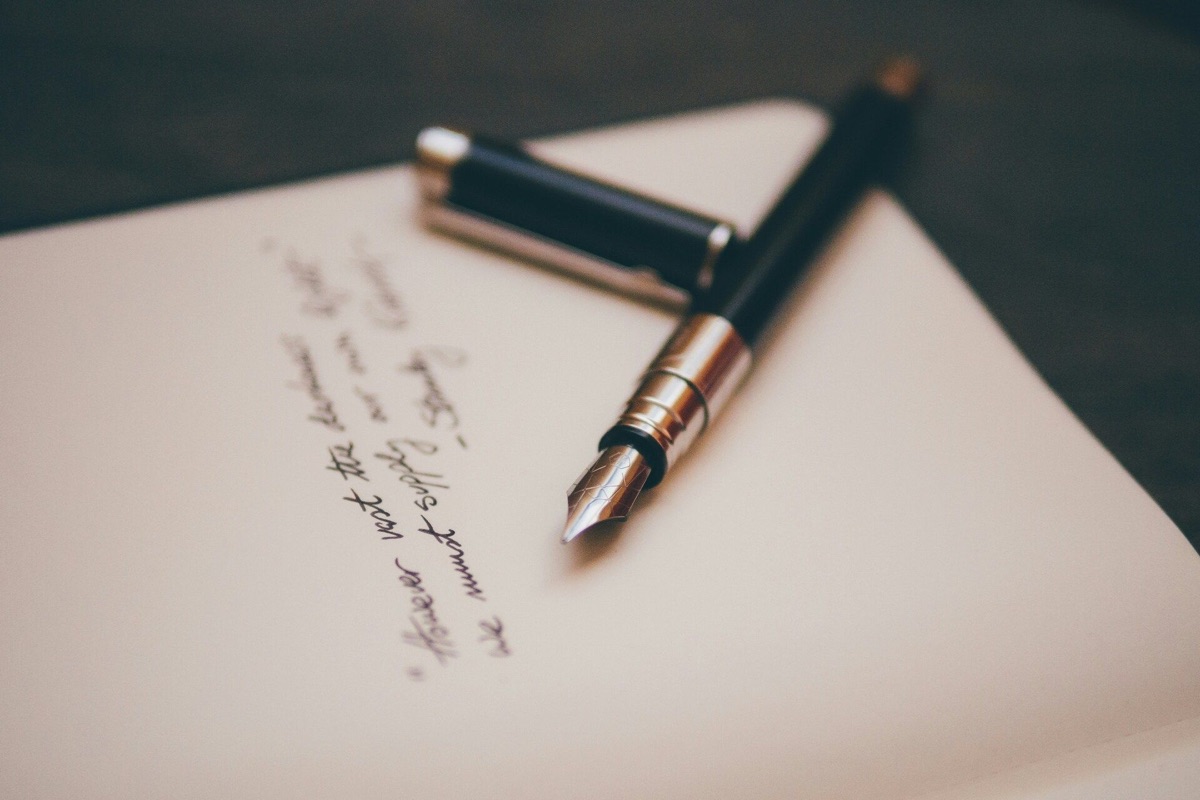 A fountain pen resting on a handwritten note